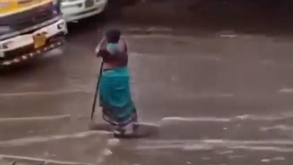 ವಾಹನ ಸವಾರರಿಗೆ ನೆರವಾಗಲು 8 ಗಂಟೆಗಳ ಕಾಲ ಸುರಿಯುವ ಮಳೆಯಲ್ಲಿಯೇ ನಿಂತ ಹೂ ಮಾರುವ ಮಹಿಳೆ