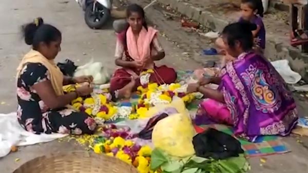 ವಾಹನ ಸವಾರರಿಗೆ ನೆರವಾಗಲು 8 ಗಂಟೆಗಳ ಕಾಲ ಸುರಿಯುವ ಮಳೆಯಲ್ಲಿಯೇ ನಿಂತ ಹೂ ಮಾರುವ ಮಹಿಳೆ